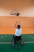 ein Foto eines Kriegsveteranen, der in einer modernen Sportarena Basketball spielt. das Konzept des Sports für Menschen mit Behinderungen