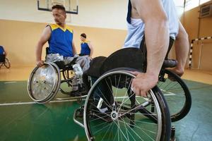 Nahaufnahme von Rollstühlen und behinderten Kriegsveteranen, die auf dem Platz Basketball spielen foto