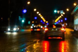 Defokussiertes Bild des nächtlichen Straßenverkehrs - Blick von der Straße. bunter hintergrund des nachtlebens. foto