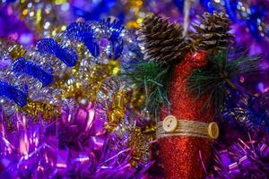 weihnachtsferien-komposition mit rotem glitzerkegel in farbigem lametta - nahaufnahme mit selektivem fokus foto