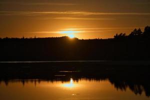 Sonnenuntergang mit Reflektion an einem schwedischen See in Smalland. romantische Abendstimmung foto