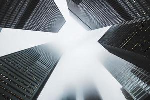 eine Low-Winkel-Aufnahme von Wolkenkratzern an einem nebligen Tag foto