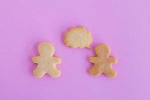 hausgemachte Shortbread-Kekse auf rosa Hintergrund, Draufsicht. zwei Personen mit Beschriftungsblase leere Nachricht. foto