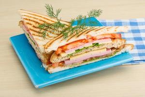 Club-Sandwich auf dem Teller und Holzhintergrund foto