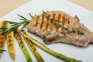 Schweinesteak auf dem Teller und Holzhintergrund foto