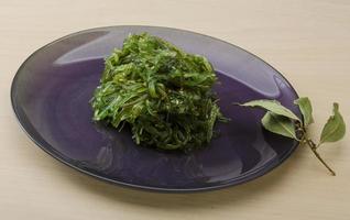 Chuka-Salat auf dem Teller und Holzhintergrund foto