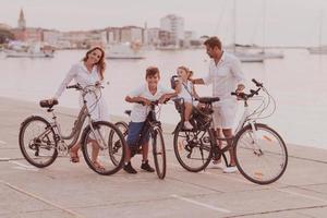 Die glückliche Familie genießt einen schönen Morgen am Meer, fährt zusammen Fahrrad und verbringt Zeit miteinander. das Konzept einer glücklichen Familie foto