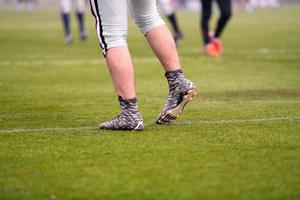 Nahaufnahme von American-Football-Spielern, die sich dehnen und aufwärmen foto