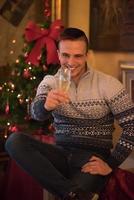 glücklicher junger Mann mit einem Glas Champagner foto