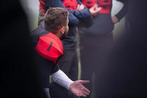 American-Football-Spieler bespricht Strategie mit seinem Team foto