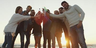 freunde auf der strandparty, die bier trinken und spaß haben foto