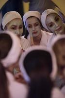 Frauen, die Gesichtsmasken ins Badezimmer legen foto