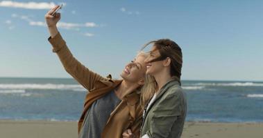 mädchen, die zeit haben und selfie am strand machen foto