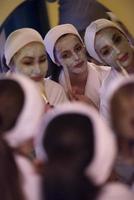 Frauen, die Gesichtsmasken ins Badezimmer legen foto
