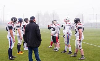 American-Football-Spieler diskutieren Strategie mit Trainer foto