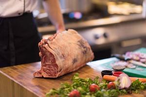 Koch schneidet ein großes Stück Rindfleisch foto