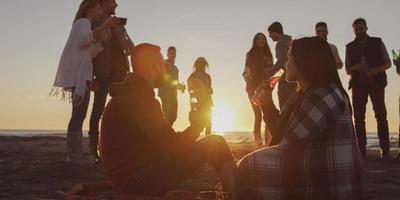 freunde, die sich am herbsttag am strand vergnügen foto