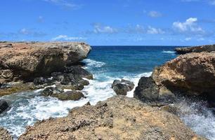 wellen, die entlang der küste von aruba zusammenbrechen foto