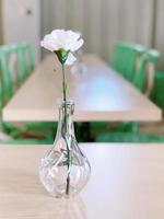 weiße Rose in einer Vase auf dem Tisch foto