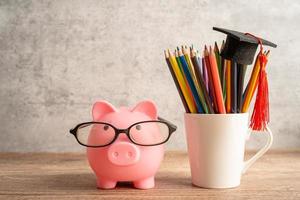 Sparschwein mit Brille mit bunten Stiften foto