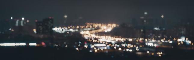 verschwommene Lichter des Straßenverkehrs bei Nacht, abstrakter, unscharfer Stadtbildhintergrund foto