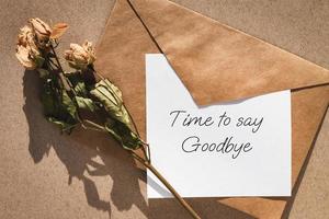 Abschiedsbrief, Briefumschlag und getrocknete Rosen foto