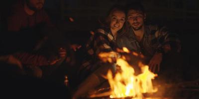 paar, das nachts mit freunden am strand genießt foto