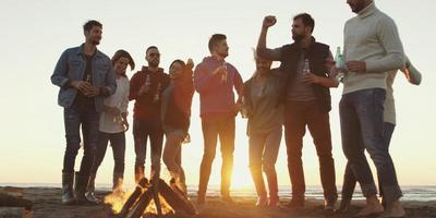 freunde, die sich am herbsttag am strand vergnügen foto