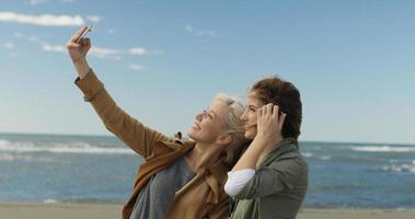 mädchen, die zeit haben und selfie am strand machen foto