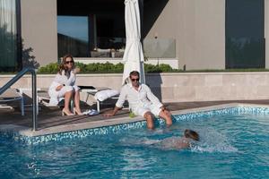 glückliche familie genießt urlaub in einem luxushaus mit pool. älteres paar verbringt zeit mit ihrem sohn während der ferien. selektiver Fokus foto