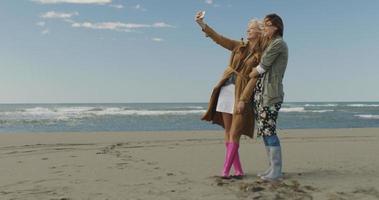 mädchen, die zeit haben und selfie am strand machen foto