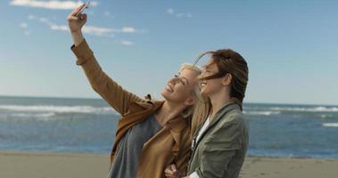 mädchen, die zeit haben und selfie am strand machen foto