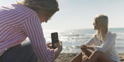 Zwei Freundinnen haben Spaß daran, sich gegenseitig im Urlaub zu fotografieren foto