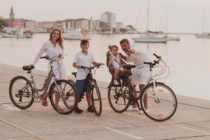 Die glückliche Familie genießt einen schönen Morgen am Meer, fährt zusammen Fahrrad und verbringt Zeit miteinander. das Konzept einer glücklichen Familie foto