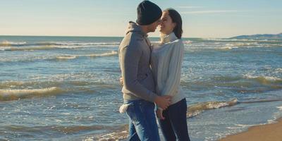 Paare, die Spaß an einem schönen Herbsttag am Strand haben foto