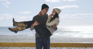 Paare, die Spaß an einem schönen Herbsttag am Strand haben foto