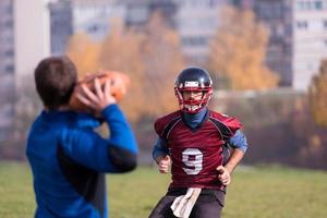 American-Football-Team mit Trainer in Aktion foto