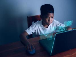 Bild des Bildungskonzepts. kreative idee und innovation. Junge, der auf den Computer starrt, und auf der Vorderseite befindet sich ein Bildungssymbol. foto