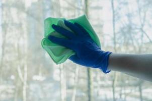 Fenster putzen. behandschuhte Hände mit Reinigungstuch foto