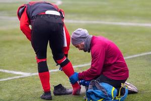 Sportarzt mit Kältespray bei der Behandlung von verletzten Sportlern foto