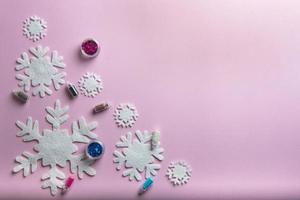 weihnachts- oder winterkomposition. Muster aus Schneeflocken auf pastellrosa Hintergrund. foto