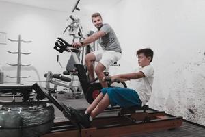 vater und sohn trainieren zusammen zu hause im fitnessstudio. das Konzept des gesunden Lebens. selektiver Fokus foto