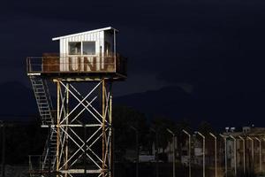 nikosia, zypern, griechenland - 2020 - ein verwitterter un-wachturm, der von der sonne mit dunklen gewitterwolken im hintergrund beleuchtet wird. foto