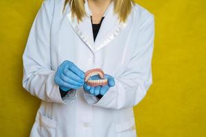 Zahnersatz in den Händen eines Zahntechnikers foto