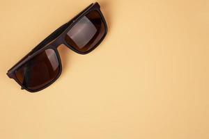 Braune solar polarisierte Schutzbrille Nahaufnahme auf einer Draufsicht des beigen Hintergrundes mit Kopienraum foto