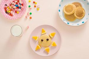 Konzeptkinderfrühstück mit Draufsicht des Pfannkuchens auf weißem Hintergrund foto