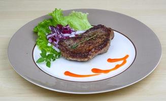 Beefsteak auf dem Teller und Holzhintergrund foto