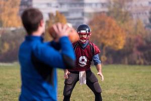 American-Football-Team mit Trainer in Aktion foto