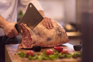 Koch schneidet ein großes Stück Rindfleisch foto