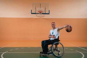 ein Foto eines Kriegsveteranen, der in einer modernen Sportarena Basketball spielt. das Konzept des Sports für Menschen mit Behinderungen